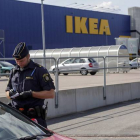 Un agente habla con unos clientes en las afueras del Ikea de Vasteras, en Suecia.
