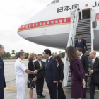 El primer ministro japones, Shinzo Abe, en el centro, es recibido por un comandante estadounidensse a su llegada a Pearl Harbor.