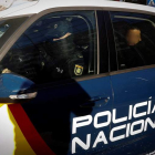 Un coche policial traslada a dos de los cinco acusados de violar a la joven madrileña. VILLAR LÓPEZ