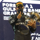 El piloto británico Lewis Hamilton celebra en el podio el triunfo en el Gran Premio de Baréin. XHEMAJ