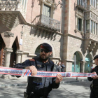 Dos agentes de los Mossos acordonan la zona mientras la Guardia Civil inspecciona la sede del Diplocat, durante un registro el pasado 12 de abril.