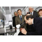 Urbano González, Mateos y Hermida observan como el presidente Herrera mira a través de un microscopi
