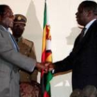 Mugabe (izquierda), mientras le da la mano a Tsvangiraie
