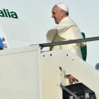 Una azafata da la bienvenida al Papa al subir a bordo del avión que le traslada a Brasil.