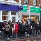 Viajeros hacen cola en la parada para acceder a los autobuses, en Brixton, en el sur de Londres, este lunes.