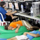 Participantes en la Campus Party descansan junto a los ordenadores.