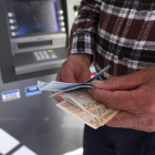 Un cliente retira dinero de un cajero automático. KATIA CHRISTODOULOU