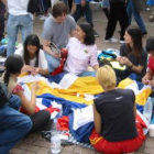Un grupo de voluntarios haciendo una «cosida colectiva» de bandera.