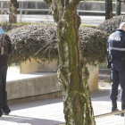 Investigadores de la Policía Nacional buscan la navaja en presencia de los testigos de los hechos.