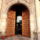 Dos mozos de Paradores en el momento del cierre de la entrada principal del hostal San Marcos. PARADORES