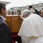Francisco posa sus manos sobre el féretro de Benedicto XVI. VATICAN MEDIA