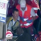 Armstrong, sentado en la cuneta, espera a ser atendido tras sufrir una caída.