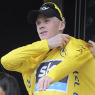 El ciclista británico Christopher Froome, del Sky, se enfunda en el podium el maillot amarillo de líder tras disputar la 18ª etapa del Tour de Francia, entre las localidades de Gap y L'Alpe d'Huez, en Francia, hoy, jueves 18 de julio de 2013.