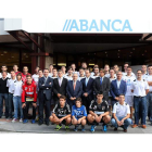 Foto de familia del equipo, plantilla y directivos, con los patrocinadores ante la sede de Abanca.