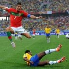 Cristiano Ronaldo hace un salto acrobático por encima de  un defensor brasileño.