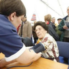 Una joven toma la tensión a una mujer mayor en las jornadas «Conectando generaciones» de