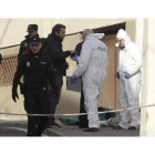 Agentes de la policía conversan a la puerta de la casa donde apareció muerta la mujer. J. M. GARCÍA