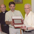 El alcalde entrega la placa al socio de mayor edad.
