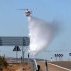 Un helicóptero arroja agua sobre el incendio, cerca de León