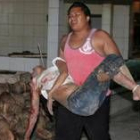 Un ciudadano indonesio traslada el cuerpo de una mujer herida tras una de las explosiones en Bali