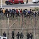 Imagen de esta mañana con el grupo de inmigrantes encaramado a la valla fronteriza.