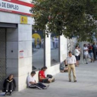 Personas hacen cola ante una oficina de empleo de Madrid.