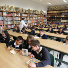 Varios niños ojean libros en una de las aulas del colegio La Asunción, que acoge a cerca de 700 alumnos que cursan desde Infantil hasta segundo de Bachillerato en el centro educativo leonés.