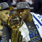Stephen Curry y Andre Iguodala besan el título de campeones de la NBA.