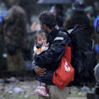 Un refugiado con su hijo al llegar a las costas griegas