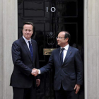 David Cameron estrecha la mano al presidente francés, François Hollande.