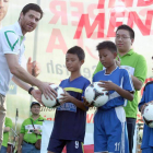 Alonso entrega balones de fútbol a jóvenes locales.