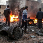Un grupo de sirios deambula entre los restos del avión ruso derribado.