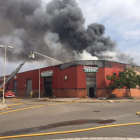 Columna de humo en la nave siniestrada en el polígono Badalona Sud.