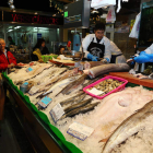 Varias personas esperan la cola en una pescadería. RAMIRO
