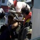 La policía y los médicos bajan del barco a un niño de año y medio