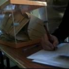 Un vocal repasa el censo de electores en una de las mesas de la capital el 14-M