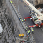 Los operarios bajan una de las piezas de las compuertas con la ayuda de una grúa.