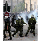 Unos jóvenes corren ante una carga policial en Atenas.