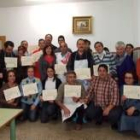 Los participantes muestran los diplomas que acreditan su participación
