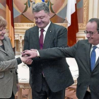 Merkel y Hollande, con el presidente ucraniano, Petró Poroshenko (en el centro), justo antes del inicio de la reunión, ayer, en Kiev.