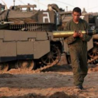 Un soldado israelí traslada un proyectil en una base en la frontera con la franja de Gaza