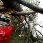 Una mujer observa los destrozos que «Iván» ha dejado en su camioneta y en el coche de a lado