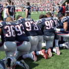 Los jugadores de New England Patriots protestan arrodillados durante el himno