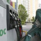 El empleado de una gasolinera de la empresa Yukos en Moscú pone combustible a un coche.