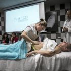 Una fisioterapeuta muestra cómo dar un masaje a una enferma de cáncer.