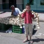 Un niño juega con los ajos durante la feria en el día de la apertura