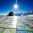 Un hombre fotografía una postal gigante compuesta por contribuciones individuales con mensajes de lucha contra el calentamiento global en el glaciar Aletsch en Jungfraujoch, en Suiza.
