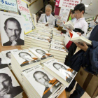 Varias personas observan la nueva biografía del fallecido cofundador de Apple, Steve Jobs, escrita por el estadounidense Walter Isaacson, que llegó a las librerias niponas, hoy.