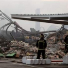 Varios bomberos, entre los restos del edificio de Leroy Merlin.