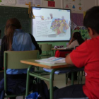 Un grupo de niños atiende las explicaciones de la plantalla electrónica en un colegio de León